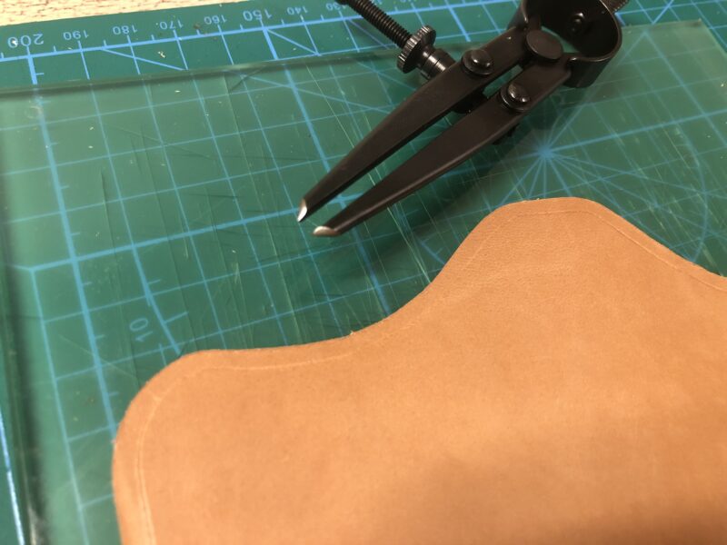 表用の革にディバイダーで縫い線を引く